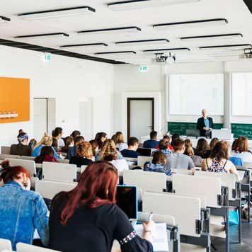 A university lecturer addressing his students in a modern lecture hall.