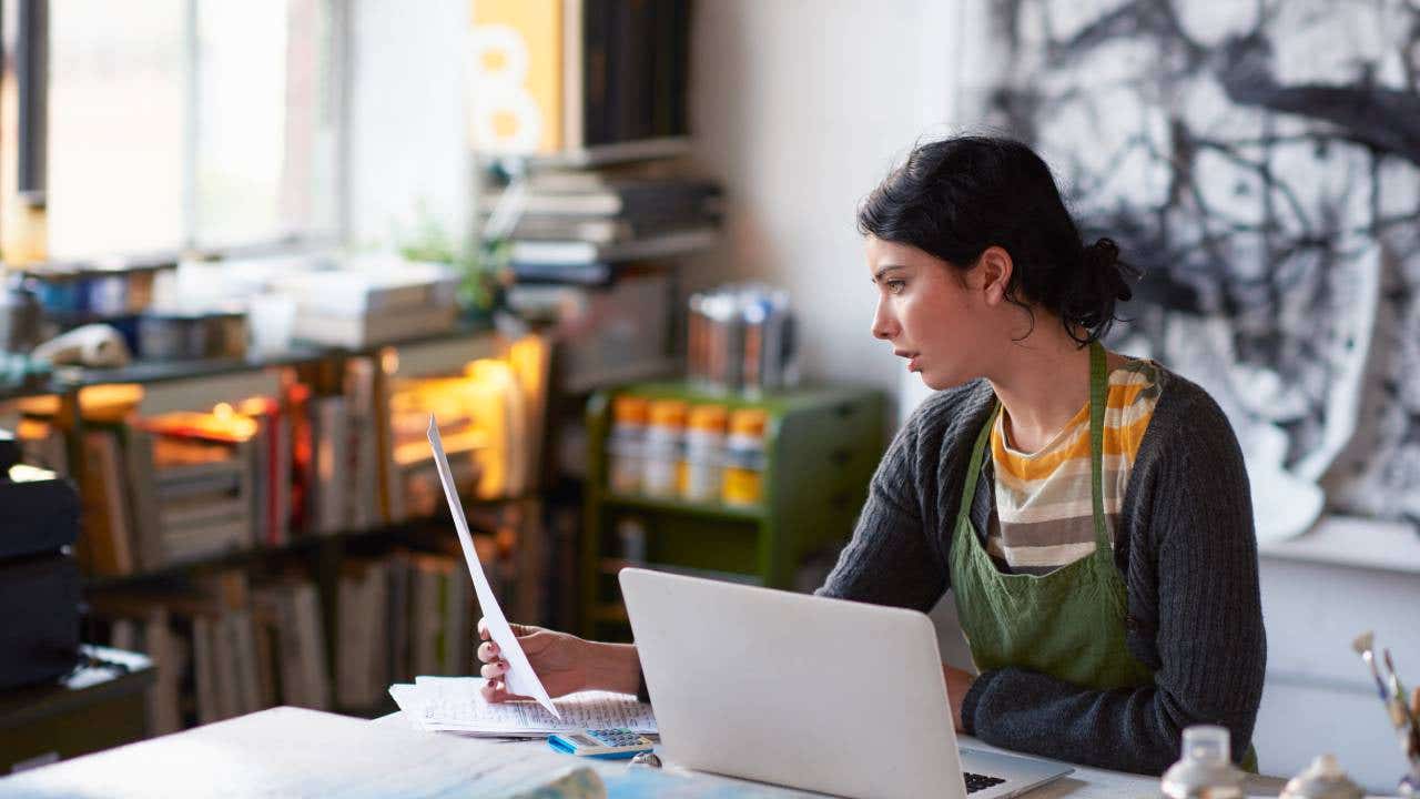 Jeune artiste féminine en studio travaillant sur ordinateur portable
