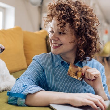 Cute girl enjoying at home with her dog and shopping online