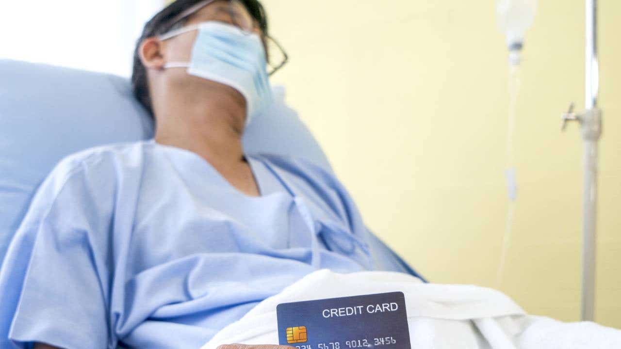 Old asian patient man showing credit card with happy smile on patient bed