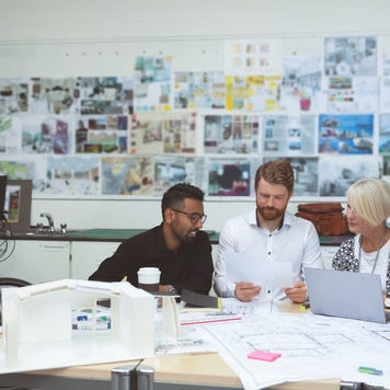 group of co-workers gathered at a table and discussing work