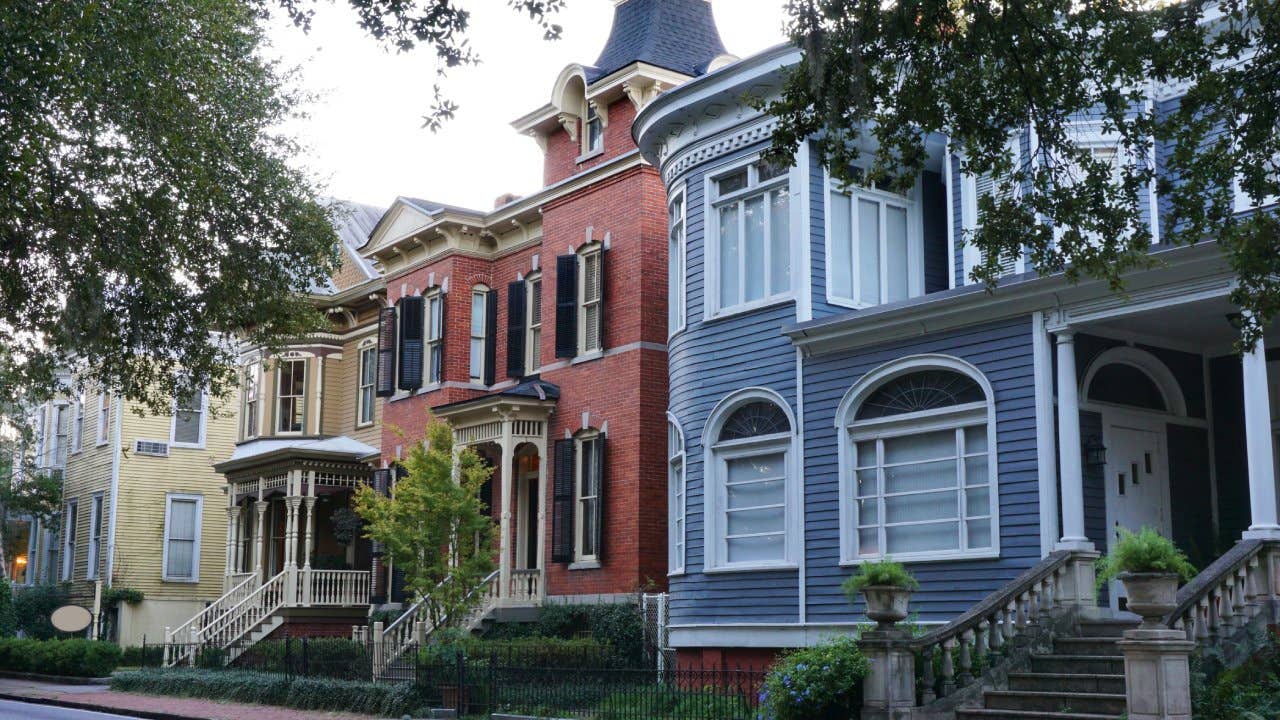 Exterior view of yellow, red, blue and brown, Victorian houses in downtown Savannah Georgia