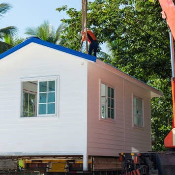 Prefabricated house crane being lifted by a crane