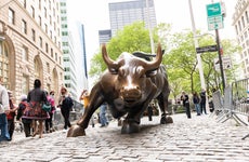 People visiting the large bronze Charging Bull statue on Wall Street