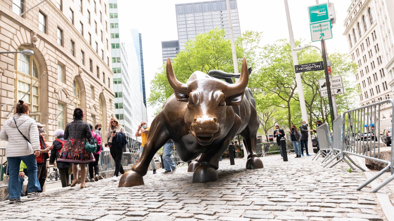 People visiting the large bronze Charging Bull statue on Wall Street