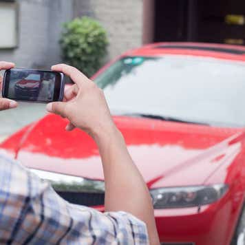 Young Man Taking a Picture of His Car