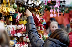 Person in a winter jacket buying Christmas ornaments off a high shelf