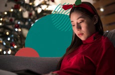 Young woman reading a tablet in a holiday decorated living room