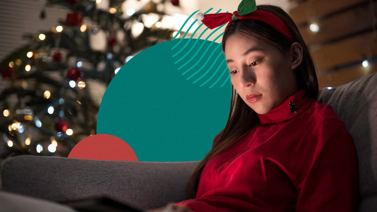 Young woman reading a tablet in a holiday decorated living room