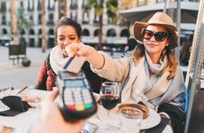 Tourist women in Barcelona paying contactless with credit card