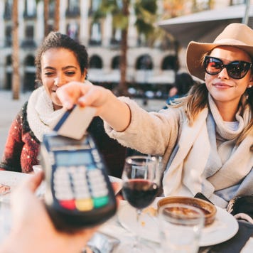 Tourist women in Barcelona paying contactless with credit card