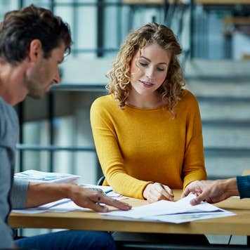 People sitting at a table, looking over documents together