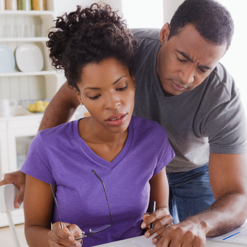 Married couple looking at paperwork with concern on their faces
