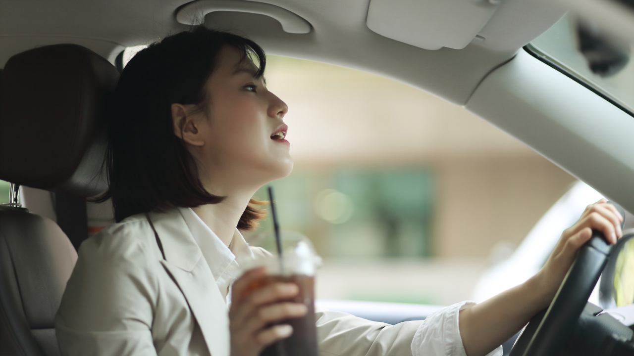 Business woman driving with coffee