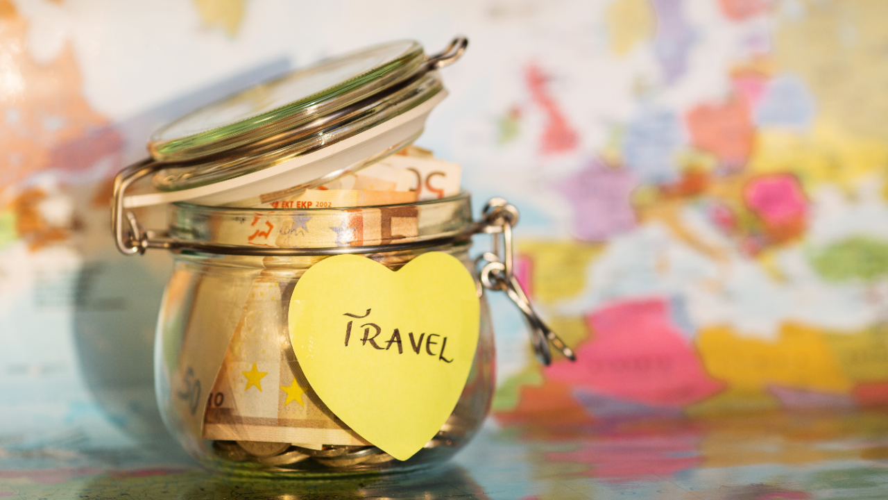 Glass jar with money inside with 'travel' written on it