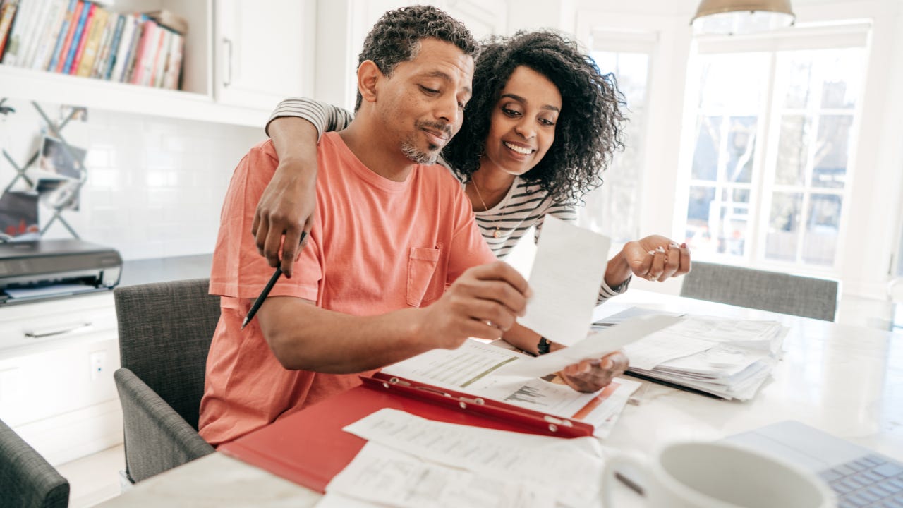 A happy couple looking over financial documents