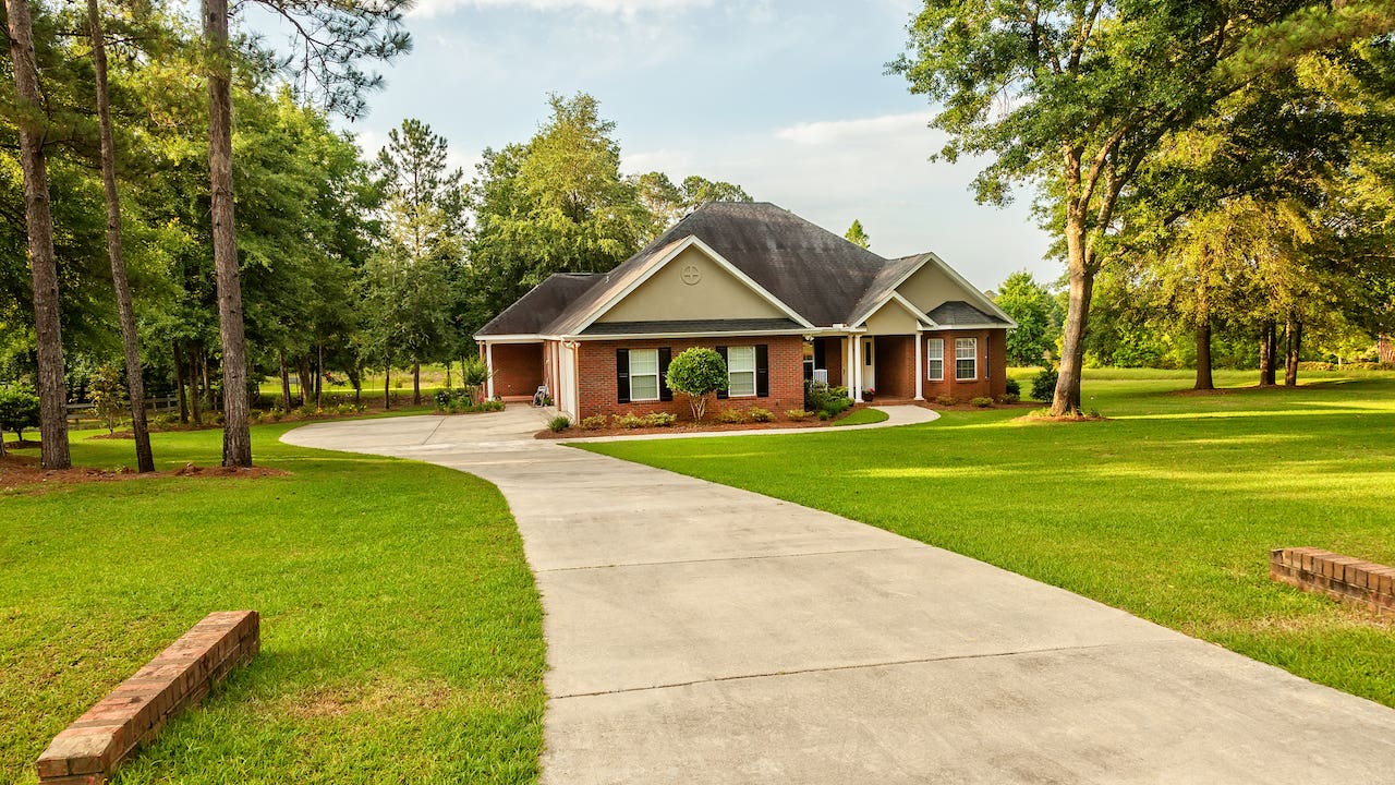 flag lot - a suburban house with a long driveway surrounded by trees