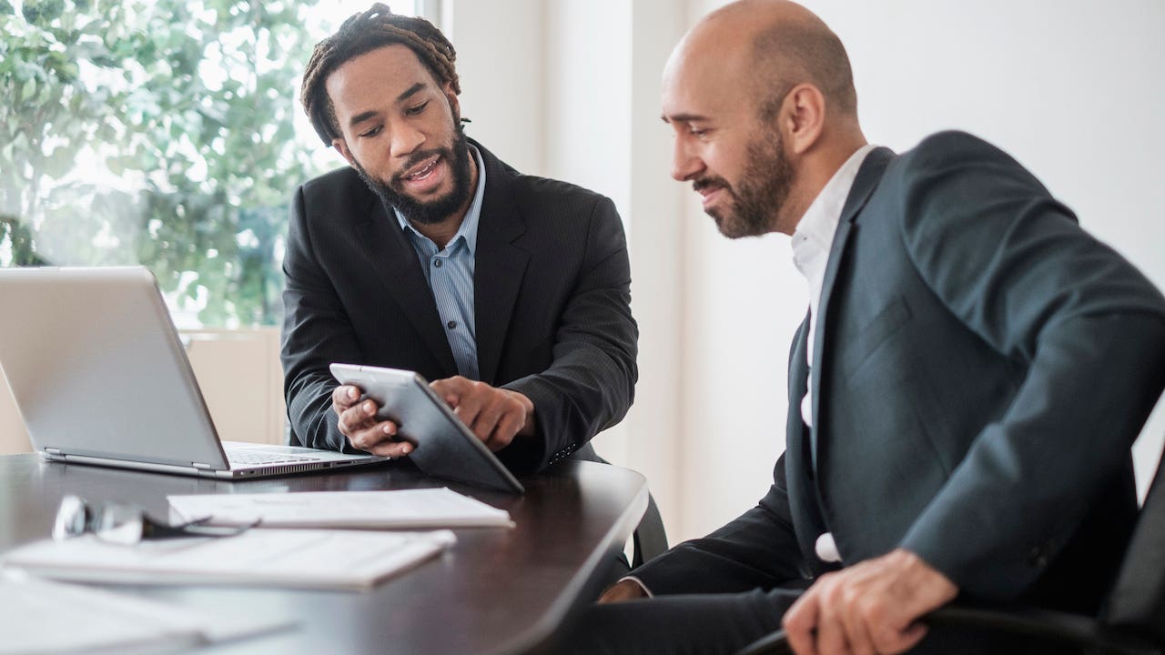 appraisal waiver - loan officer explaining data on computer and tablet to a client