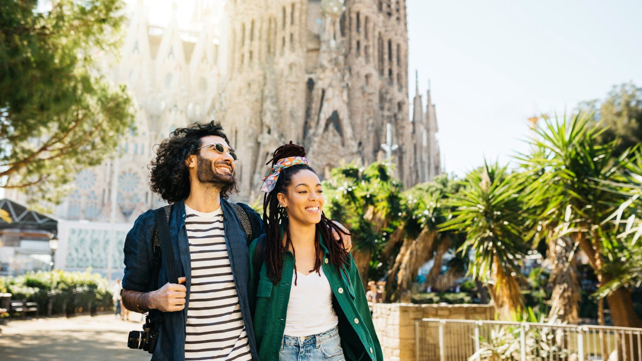 Smiling couple walking around Sagrada Familia church at Barcelona, Catalonia, Spain