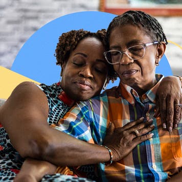 A mother and child (adult) sit together on a couch.