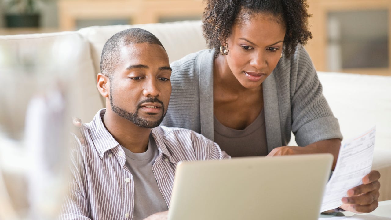 Black couple paying bills using laptop