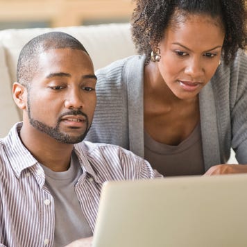 Black couple paying bills using laptop