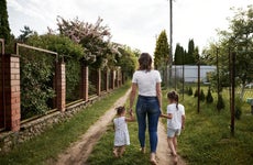 mother walking with two girls in backyard