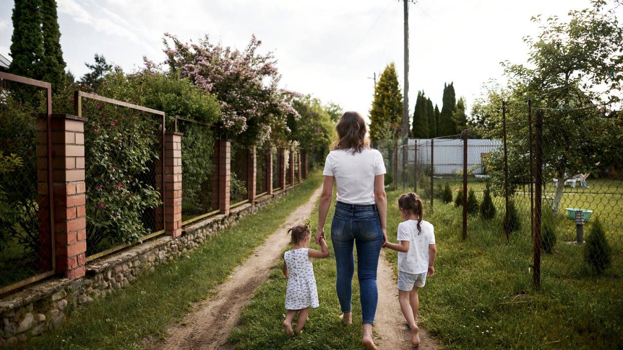 mother walking with two girls in backyard