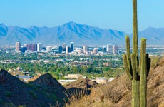 Phoenix skyline framed by saguaro cactus and mountainous desert
