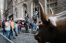 People pose by the New York stock market bull statue