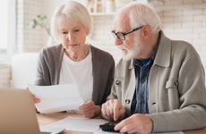 Elderly couple seriously reviewing financial documents