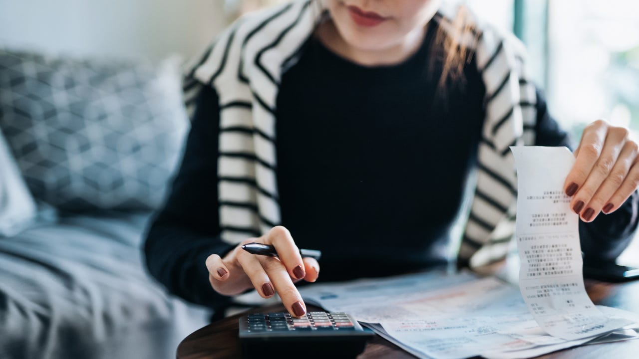 Cropped shot of young woman managing personal banking and finance at home