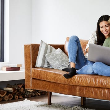 Couple on couch at home looking at laptop
