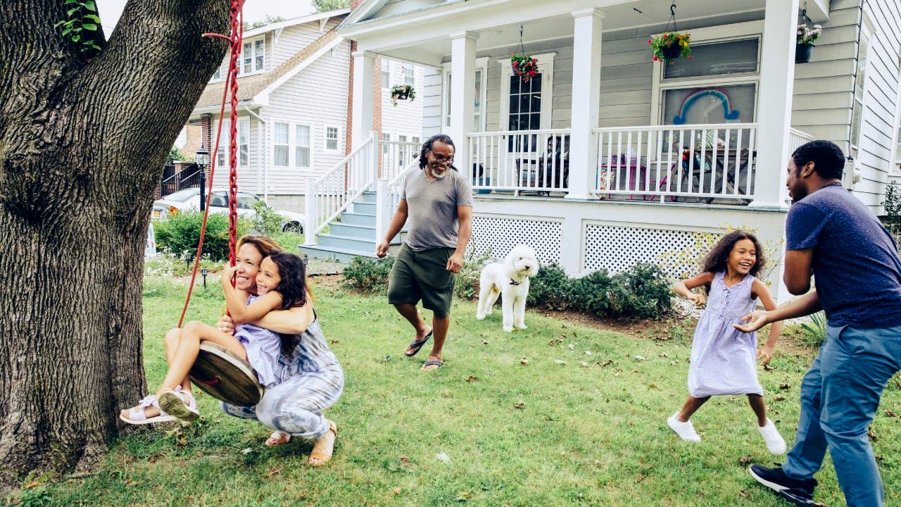 Happy family playing in front year at home