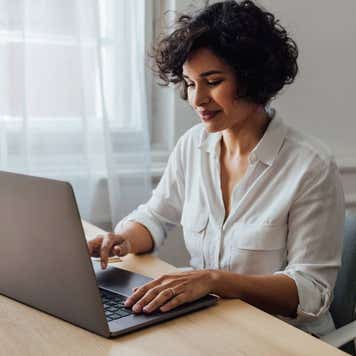 A mixed-race businesswoman typing on her computer.