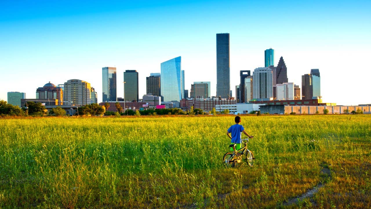 A boy looks toward the skyline in Houston, TX