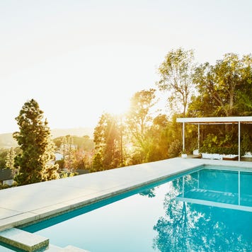 A pool in the backyard of a home during sunset