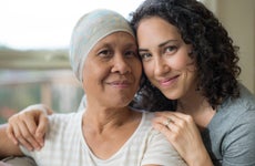 Ethnic young adult female hugging her mother who has cancer
