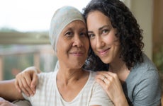 Ethnic young adult female hugging her mother who has cancer