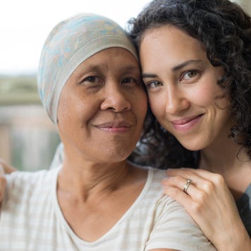 Ethnic young adult female hugging her mother who has cancer