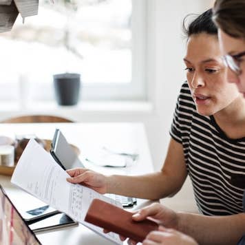 Lesbian couple discussing over financial bills while using laptop at table