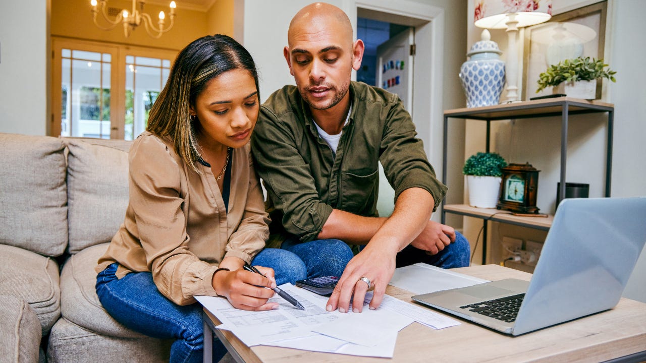 Couple looking at papers and laptop