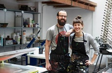 A young couple smiles in a commercial kitchen.