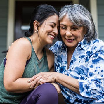 Senior woman and adult daughter laughing on porch