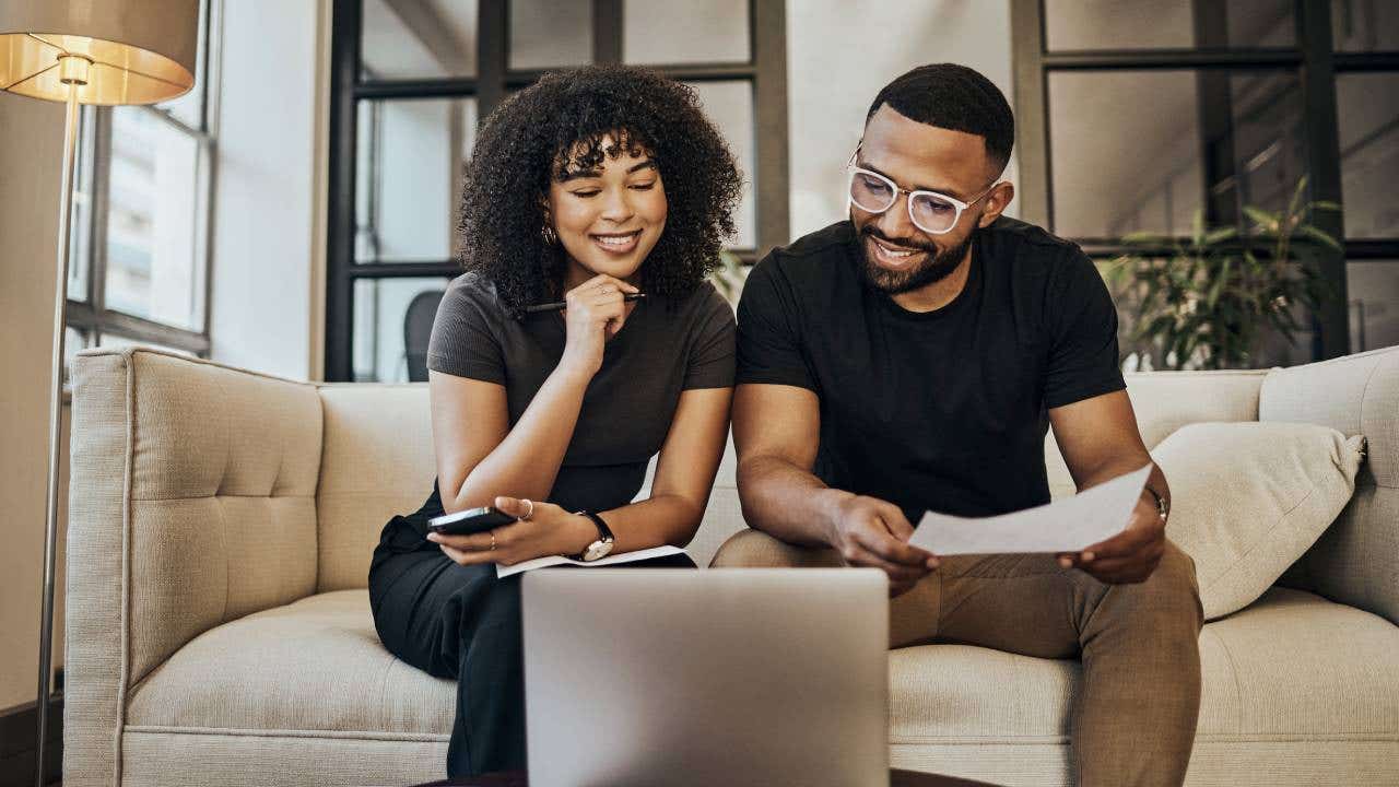 Black couple, online banking and finance documents for bill payments at home.