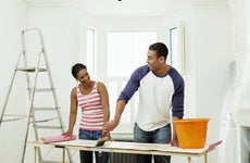 Man and woman preparing to hang wallpaper