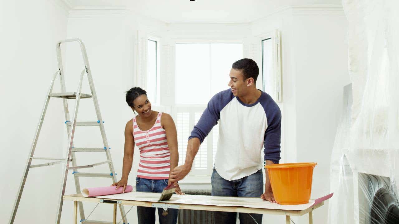 Man and woman preparing to hang wallpaper