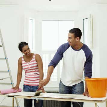 Man and woman preparing to hang wallpaper