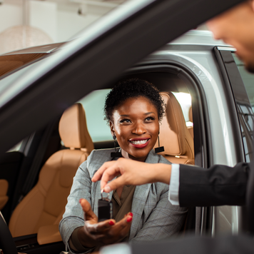 Person purchasing a vehicle and being handed the keys by a sales rep.