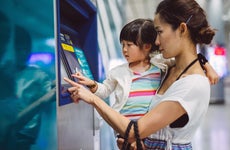mother at bitcoin atm with toddler